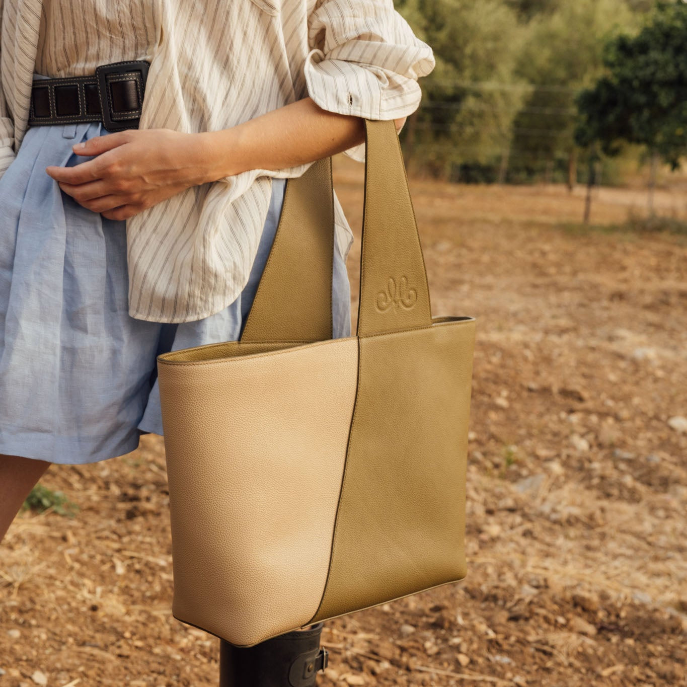 Bolso artesanal de piel vacuna, hecho en España. Diseño estructurado, amplio y elegante, con asa reversible y cierre magnético interior.